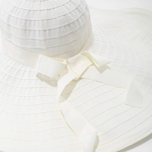 Elegant white wide brim sun hat with ribbon bow, featuring textured summer sun protection fabric