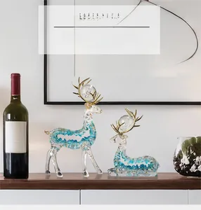 Close-up of transparent resin deer statues with blue stones and golden antlers