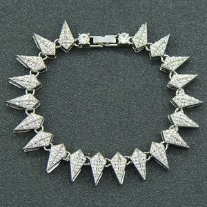 Macro shot of silver spike bracelet links encrusted with sparkling rhinestones on black