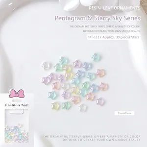 Macro shot of 7mm macaron star resin nail charms with glitter on a white petal tray