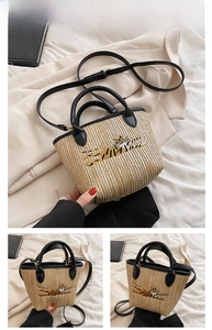 Close-up of woven straw bucket bag with black leather handle and tiger embroidery