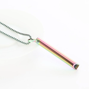 Macro shot of colorful cylindrical meditation breathing pendant on a box chain