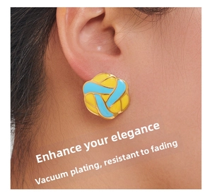 Detail of flower enamel earrings in blue and yellow with gold plating on model's ear