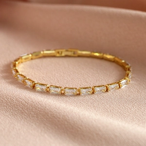 Elegant gold tennis bracelet featuring rectangular AAA zircons on soft pleated fabric