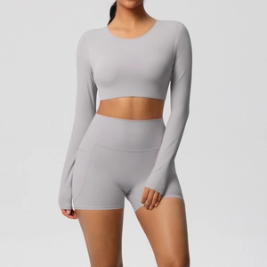 Detail van grijze yoga crop top met lange mouwen en korte broek met zijzak