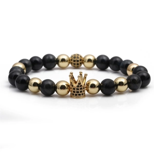 Detailed macro view of beaded crown bracelet with black natural stones and gold accents