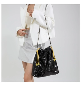 Détail du sac seau à paillettes noires avec cordon de serrage jaune contrasté