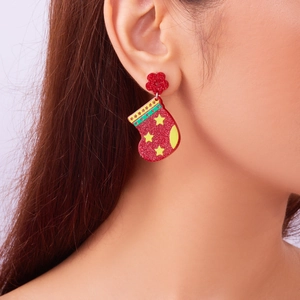 Close-up of red glitter acrylic Christmas stocking earrings with star detail on person