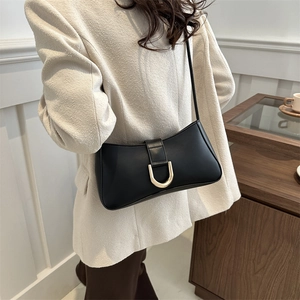 Minimalist black underarm bag with gold D-buckle and sleek faux leather finish