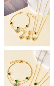 Detail of gold heart jewelry set with green gemstones, necklace and bracelet set