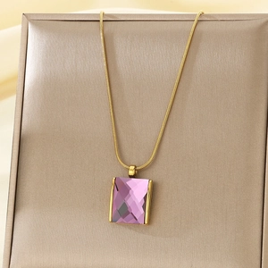 Detailed shot of a vintage gold chain with a purple rectangular glass gemstone pendant