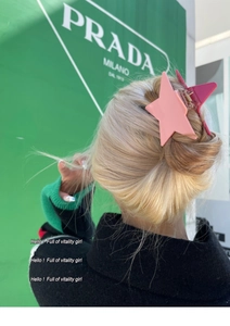 Detailed back view of pink star-shaped glitter hair claw clip on blonde hair
