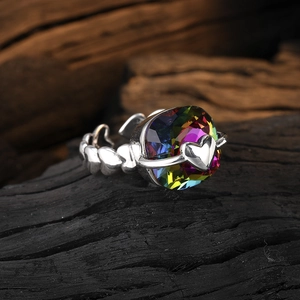 Silver open ring with rainbow heart crystal and textured band on dark background