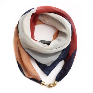 Macro shot of geometric print chiffon scarf with golden magnetic ball clasp on white base