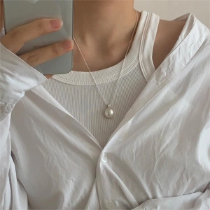 Minimalist silver O-chain necklace with a white pearl pendant shown on a model