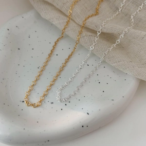 Elegant 925 sterling silver heart chain necklace in gold and silver finish on ceramic plate