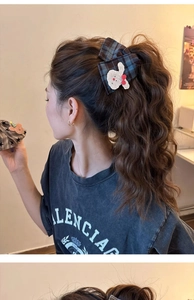 Detail of blue plaid bow hair claw clip with cute 3D bunny patch on wavy hairstyle