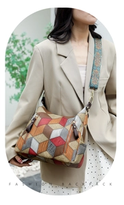 Detail of multi-color geometric patchwork tote bag with wide patterned strap and gold hardware