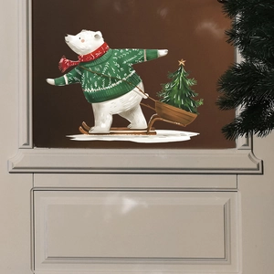 Detail of Christmas polar bear window sticker on glass door with a sled and tree