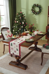 Close-up of Christmas table runner with snowflakes and trees set on a festive dining table