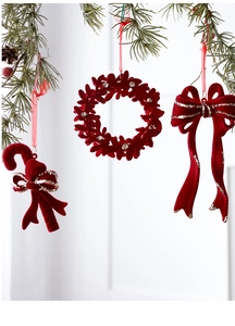 Close-up of burgundy flocked Christmas bows and candy canes with silver glitter on pine branches