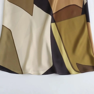 Detailed view of satin dress fabric with geometric prints and professional stitching