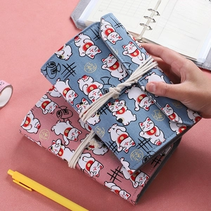 Japanese style fabric ledger book with lucky cat embroidery and cotton strap closure