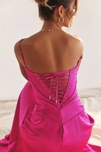 Detailed view of the criss-cross lace-up back design on a magenta satin evening dress