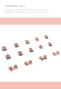 Detail view of short square gradient pink nails with green French tips and white floral accents