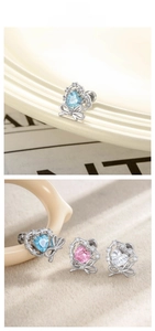 Macro detail of heart-shaped zircon earrings with micro-inlaid bow in pastel colors