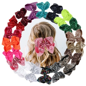 Detailed view of colorful sequined bow hair clips arranged in a circular pattern for girls