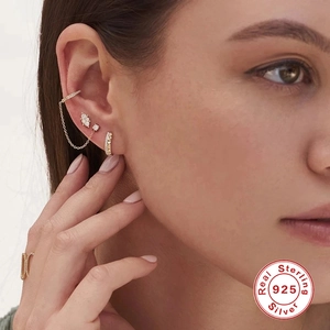Detail of 925 sterling silver tassel earrings and gold ear cuffs with cubic zirconia