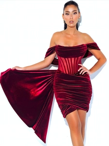 Détails de la texture du velours bordeaux et de l'ourlet asymétrique de la robe