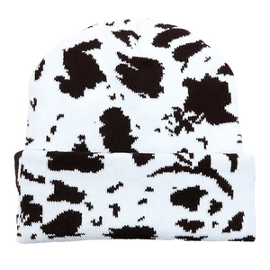 Fashionable cow print knit beanie hat in classic black and white patterned knit texture