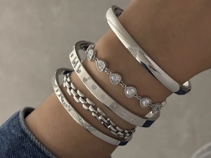 Vue détaillée de bracelets superposés en acier inoxydable argenté avec zircons micro-pave