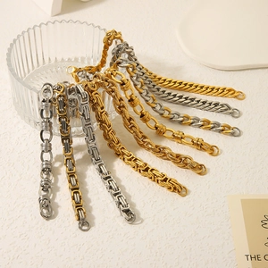 Variety of 18K gold plated and silver stainless steel chains hanging on a glass cup