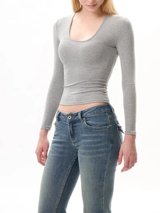 Gros plan d'un haut en maille gris ajusté à col en U assorti à un jean bleu, style épuré chic