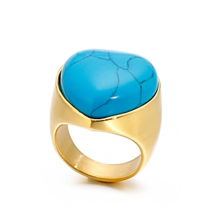 Chunky gold stainless steel ring featuring a heart-shaped turquoise stone on white background