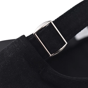 Close-up of black cotton baseball cap showing adjustable silver metal buckle and texture
