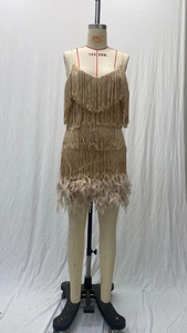 Detail eines champagnergoldenen Stufen-Fransenkleids mit weichem Federbesatz am Saum