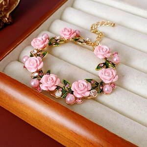 Détail du bracelet avec rose en résine rose, perles nacrées et feuilles d'or strass