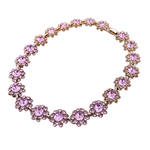 Rose gold flower bracelet featuring purple crystals and rhinestones on a white background