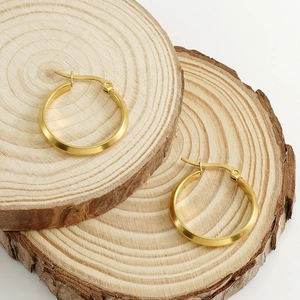 Minimalistische 18K vergoldete Edelstahl-Ohrringe auf natürlichen Holzscheiben