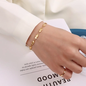 Minimalist 18k gold plated fish charm bracelet and sleek gold ring on female model