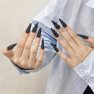 Matte black stiletto press-on nails featuring 3D snake design for a bold fashion look