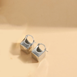 Detailed view of minimalist silver cube drop earrings with polished metallic finish
