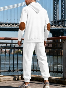 Détail d'un survêtement blanc avec texture jacquard et empiècements marrons aux coudes