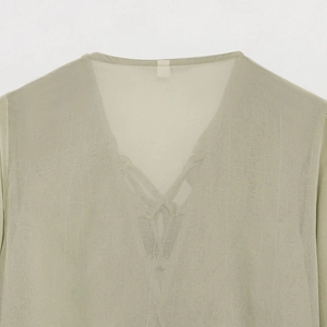 Detail of V-neckline on light sage green sheer blouse showing fabric texture