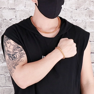 Men's hip hop gold cuban link necklace and bracelet set styled on a male model