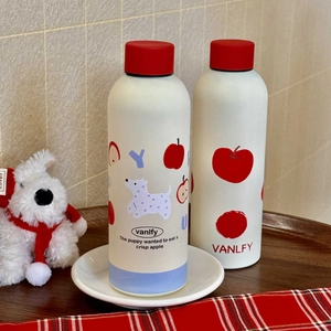 Close-up of portable insulated puppy print water bottle on a cozy wooden tray